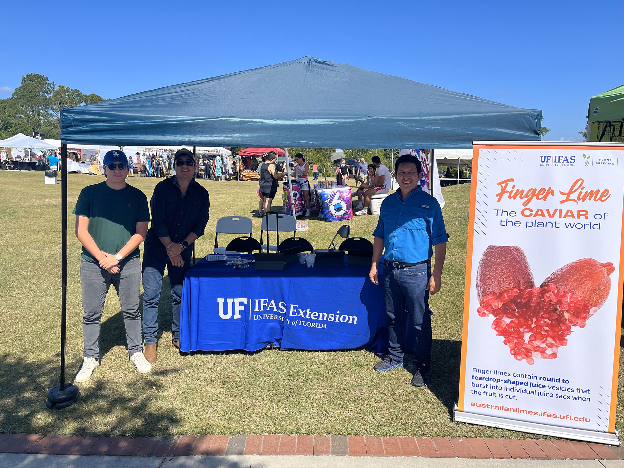 Three men standing with Finger lime display